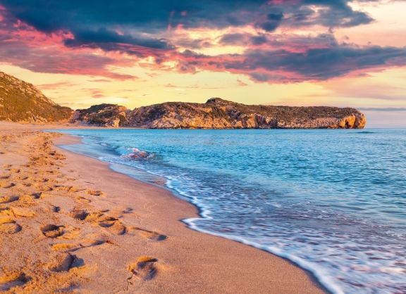 Footprints in the sand on the famous Turkish beach Patara. Colorful sunset in the Turkey, District of Kas, Antalya Province, Asia. Artistic style post processed photo.