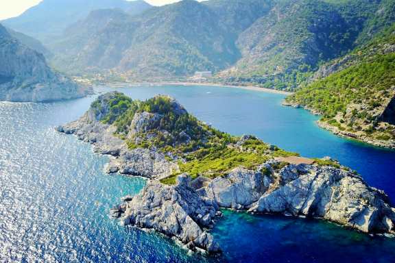 Clear waters and pine-backed coast at Çiftlik Bay near Marmaris, Turkey